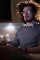 hombre trabajando en una computadora en una oficina oscura foto