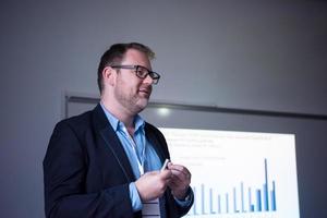 exitoso hombre de negocios dando presentaciones en la sala de conferencias foto