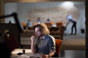 man working on computer in dark office photo