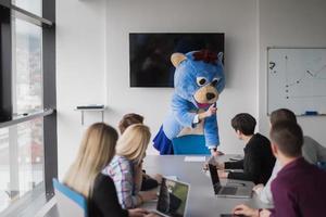 boss dresed as bear having fun with business people in trendy office photo