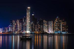 horizonte de la ciudad de panamá en la noche con agua que refleja la luz foto