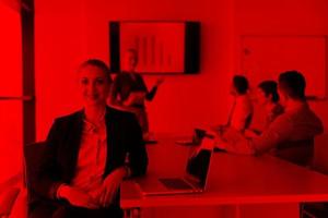 portrait of young business woman at office with team on meeting in background photo