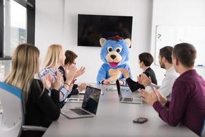 jefe vestido como oso divirtiéndose con gente de negocios en una oficina de moda foto