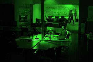 hombre trabajando en una computadora en una oficina oscura foto