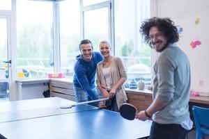 equipo de negocios de inicio jugando tenis de ping pong foto