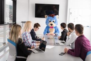 boss dresed as bear having fun with business people in trendy office photo