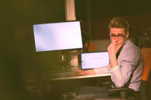 man working on computer in dark office photo