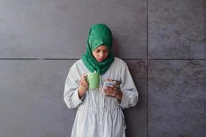 african muslim businesswoman with green hijab using mobile phone photo