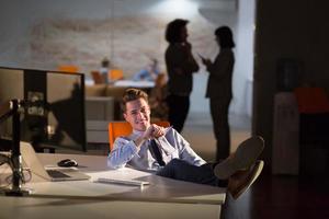 businessman sitting with legs on desk at office photo