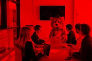 boss dresed as bear having fun with business people in trendy office photo