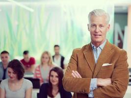 portrait of in teacher in classroom with students group in background photo