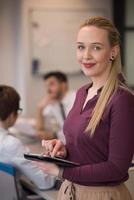 blonde businesswoman working on tablet at office photo