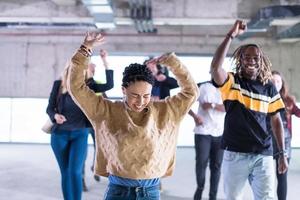 jóvenes empresarios multiétnicos bailando en una oficina de inicio sin terminar foto