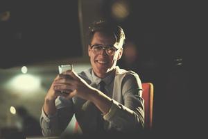 man using mobile phone in dark office photo