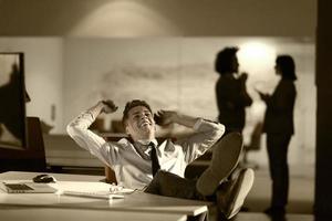 businessman sitting with legs on desk at office photo