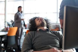 young businessman relaxing at the desk photo