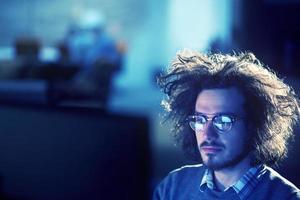 hombre trabajando en una computadora en una oficina oscura foto