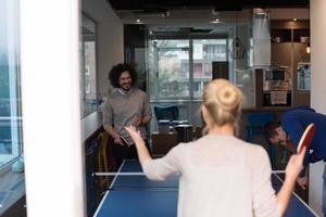 equipo de negocios de inicio jugando tenis de ping pong foto