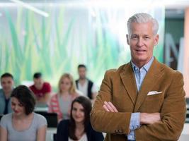 portrait of in teacher in classroom with students group in background photo