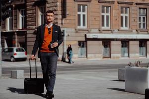 Businessman with suitcase walks down the street photo