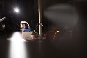 hombre trabajando en una computadora en una oficina oscura foto