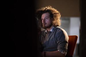 hombre trabajando en una computadora en una oficina oscura foto