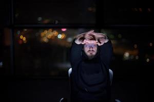 hacker using laptop computer while working in dark office photo