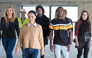 young multiethnic business people walking through unfinished startup office photo