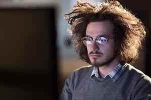 hombre trabajando en una computadora en una oficina oscura foto