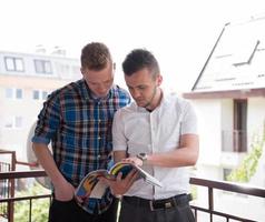 young men standing at balcony photo