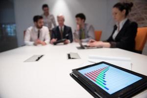 close up of touchpad with analytics documents at business meeting photo