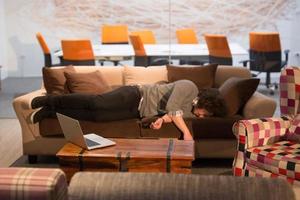 man sleeping on a sofa  in a creative office photo