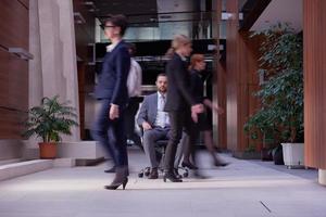 business man sitting in office chair, people group  passing by photo
