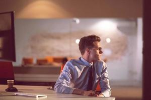 man working on computer in dark office photo