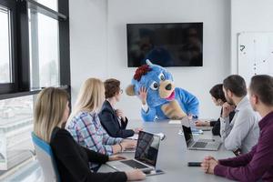 boss dresed as bear having fun with business people in trendy office photo