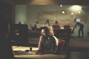 man working on computer in dark office photo