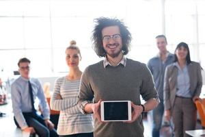 Portrait of a young businessman holding tablet photo