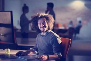 man working on computer in dark office photo