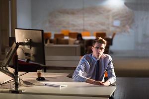 man working on computer in dark office photo