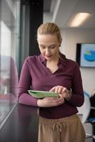 blonde businesswoman working on tablet at office photo