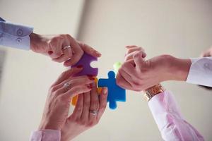 business people group assembling jigsaw puzzle photo