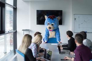 boss dresed as bear having fun with business people in trendy office photo