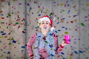 business woman wearing a red hat and blowing party whistle photo