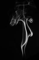 A single white smoke burn from incense, shot in studio with dark black background, for design and religion concept photo