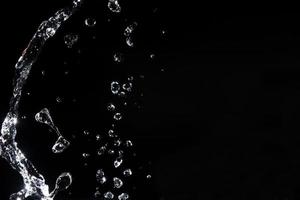 Water splash shot in studio, white water and black background, pure water for drink and food concept copy space for text and design photo