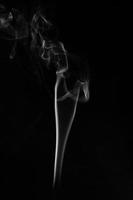 una sola quemadura de humo blanco de incienso, filmada en estudio con fondo negro oscuro, para el concepto de diseño y religión foto