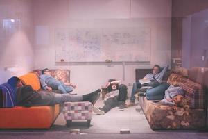 software developers sleeping on sofa in creative startup office photo