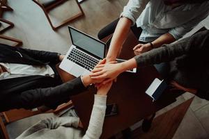 Close up of young business people putting their hands together. Stack of hands. Unity and teamwork concept.. photo