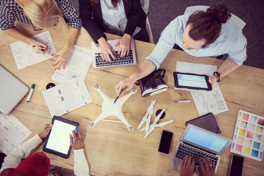 top view of multiethnic business team learning about drone technology photo