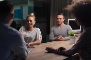 Multiethnic startup business team in night office photo